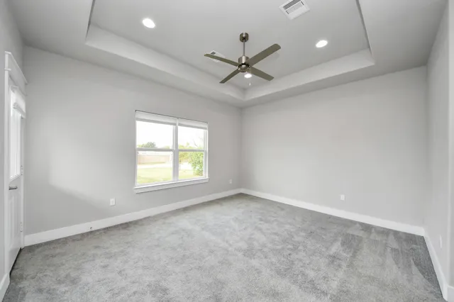 an empty room with a window and a fan