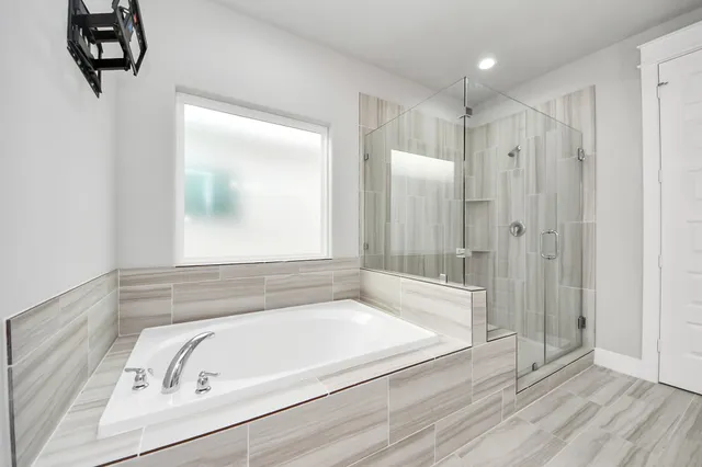 a bathroom with a tub a sink and a window