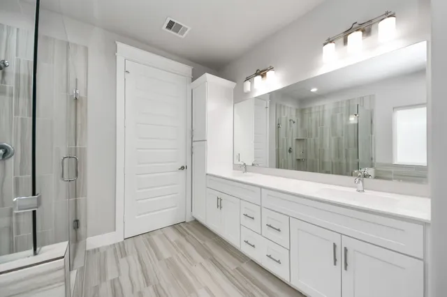 a bathroom with a double vanity sink and mirror