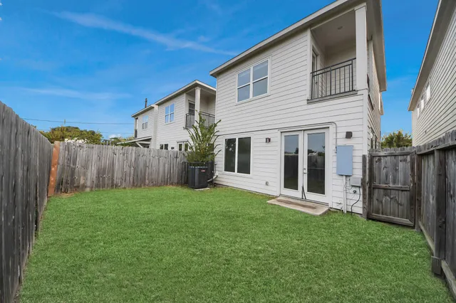 a view of a house with backyard and a fence