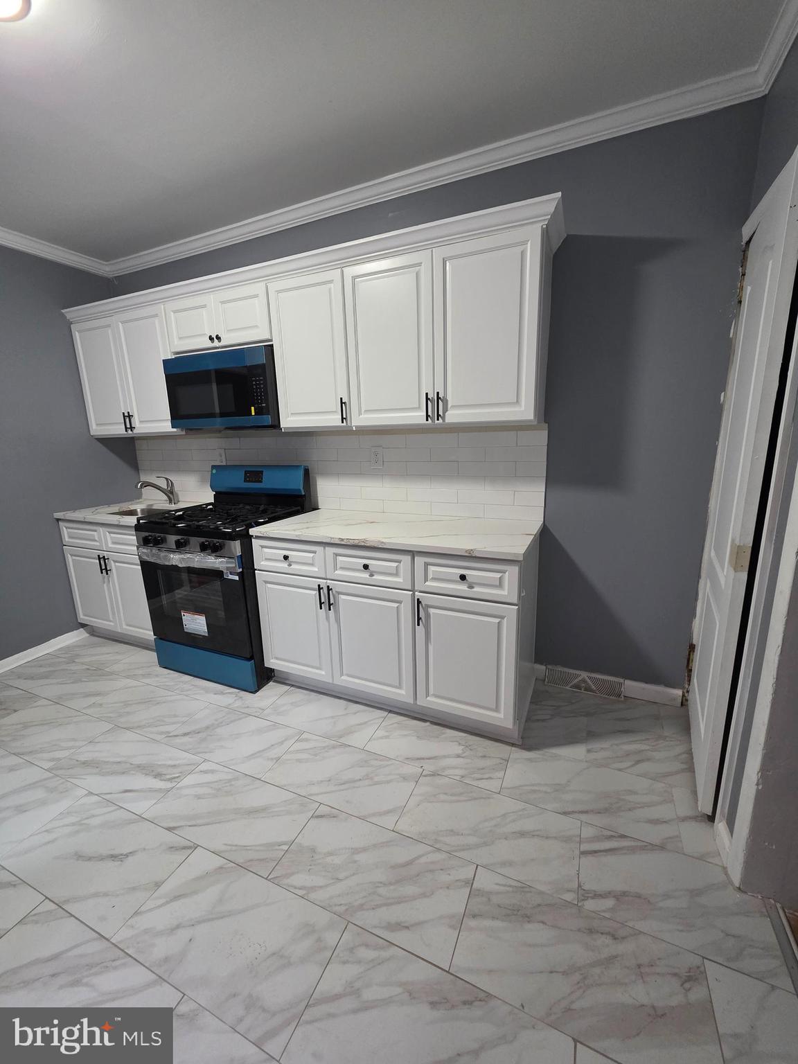 521 Birch Street Reading, PA 19604 - Photo 4 of 16 a kitchen with stainless steel appliances granite countertop a stove a sink and a microwave