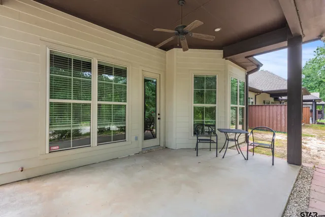 a view of a house with a large window and wooden fence