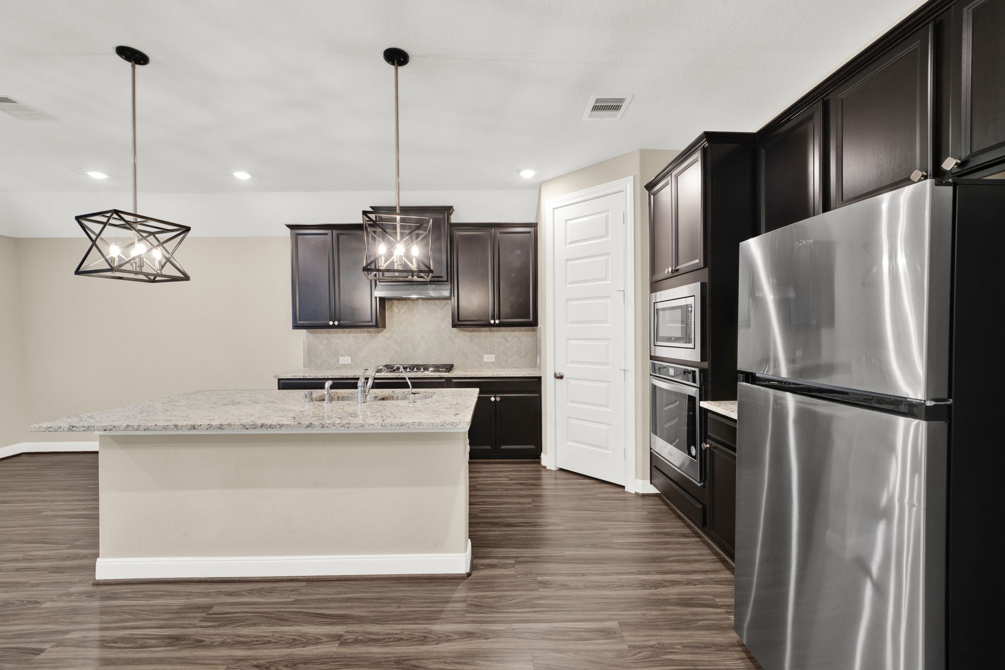 2217 Gadwall Court Conroe, TX 77384 - Photo 6 of 35 a kitchen with stainless steel appliances granite countertop a refrigerator a stove a sink and a refrigerator