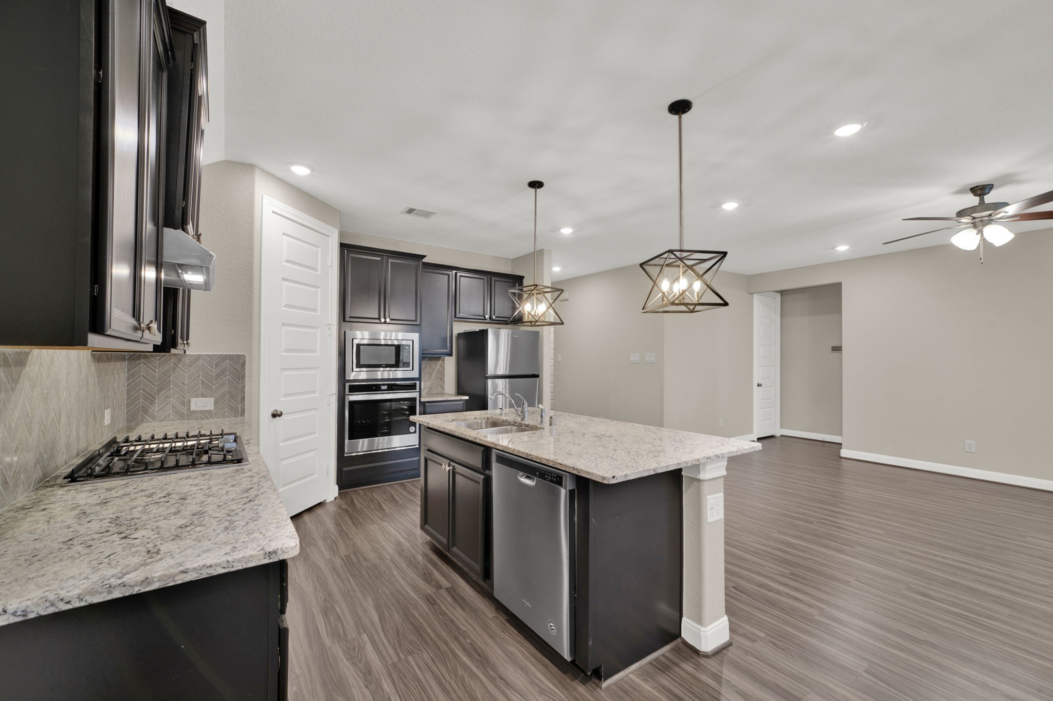 2217 Gadwall Court Conroe, TX 77384 - Photo 8 of 35 a kitchen with stainless steel appliances granite countertop a kitchen island a stove and a sink
