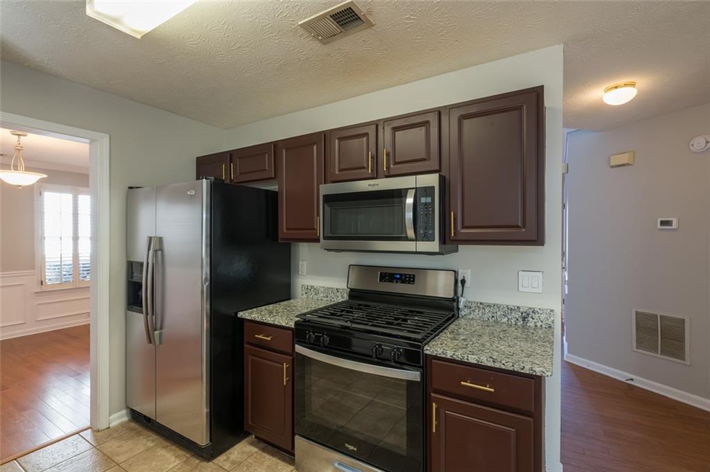 3789 Seattle Place Northwest Kennesaw, GA 30144 - Photo 11 of 40 a kitchen with stainless steel appliances granite countertop a stove microwave and refrigerator