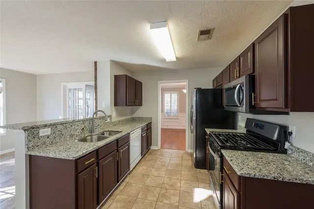 a kitchen with stainless steel appliances granite countertop a stove and a sink