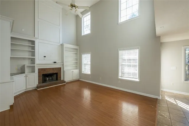 wooden floor fireplace and windows in an empty room