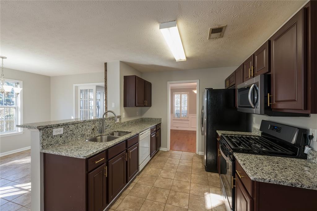 3789 Seattle Place Northwest Kennesaw, GA 30144 - Photo 15 of 40 a kitchen with a granite countertop sink stove and refrigerator