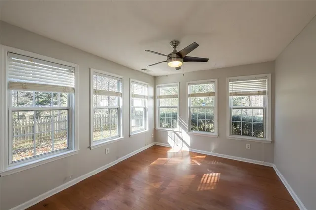 a view of an empty room with a window and a kitchen