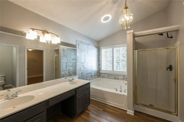 a bathroom with a bathtub a double vanity sink and large mirror