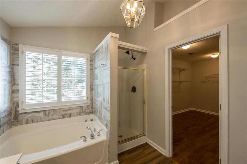 3789 Seattle Place Northwest Kennesaw, GA 30144 - Photo 29 of 40 a bathroom with a bathtub and a shower