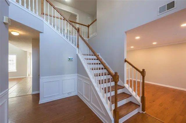 a view of staircase with wooden floor and white walls