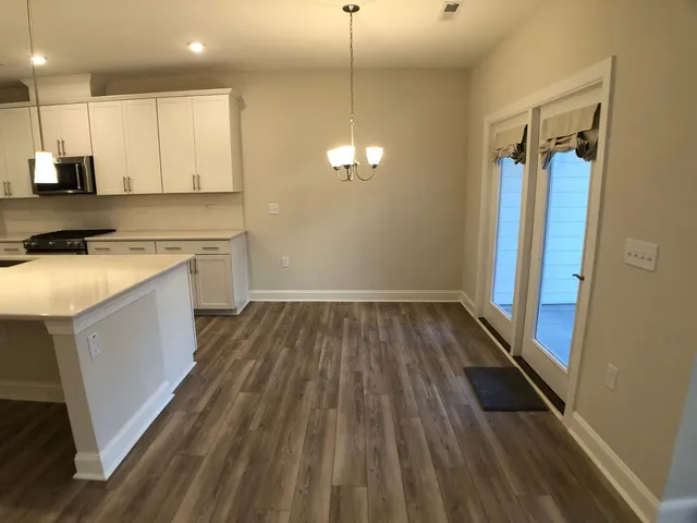 a view of a kitchen with wooden floor and a sink