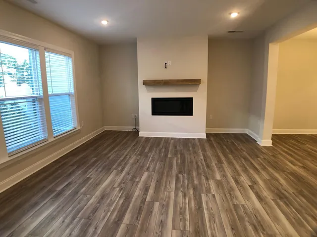 an empty room with wooden floor and a fireplace