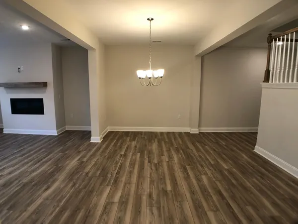 a view of a livingroom with wooden floor and staircase