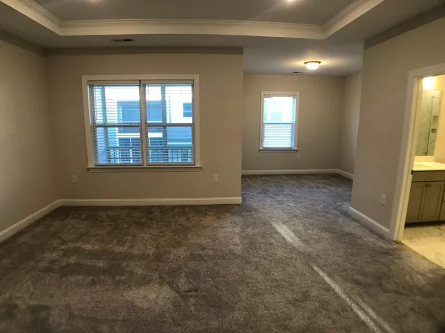 an empty room with a fireplace and windows