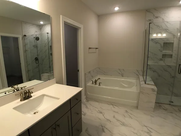 a bathroom with a tub sink double vanity and a mirror