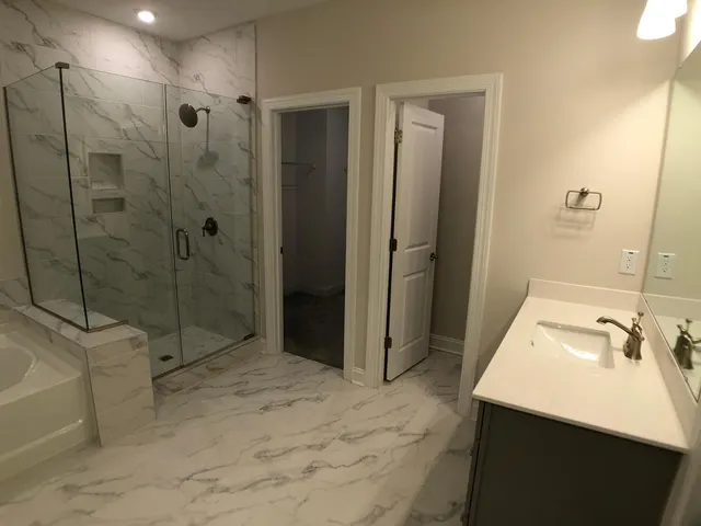 a bathroom with a sink a toilet and shower