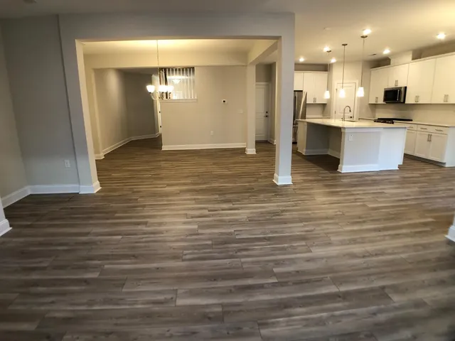 a view of kitchen with kitchen island wooden cabinets and refrigerator