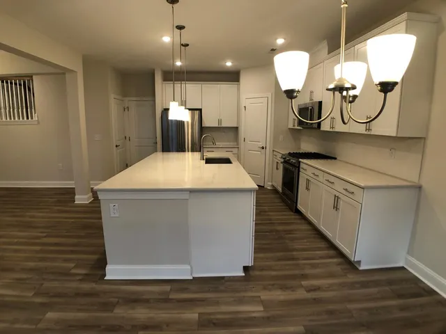 a kitchen with kitchen island a counter top space a sink and appliances