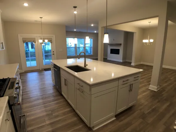 a kitchen with stainless steel appliances granite countertop a sink and a wooden floors