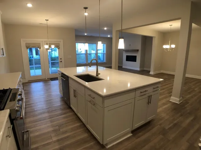 a kitchen with stainless steel appliances granite countertop a sink and a wooden floors