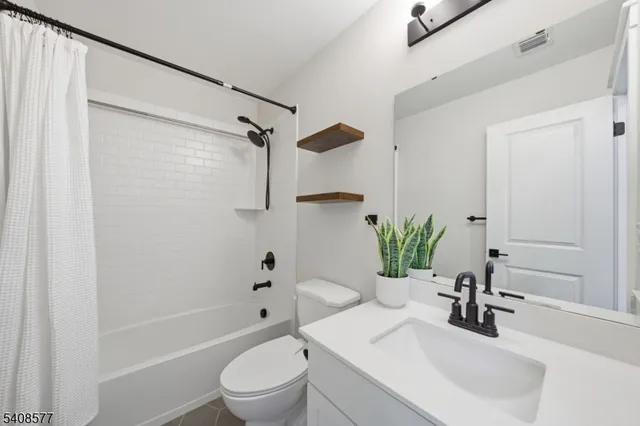 a bathroom with a sink a toilet a tub and shower