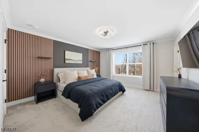 a bedroom with a large bed and a flat tv screen on dresser