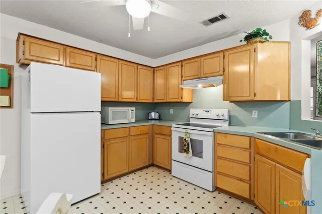 a kitchen with a stove a sink and a microwave