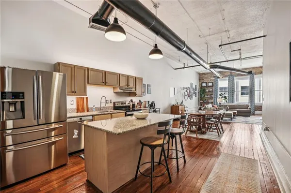a kitchen with sink a refrigerator and wooden floor
