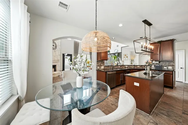 a kitchen island with stainless steel appliances kitchen island granite countertop a sink a dining table and chairs