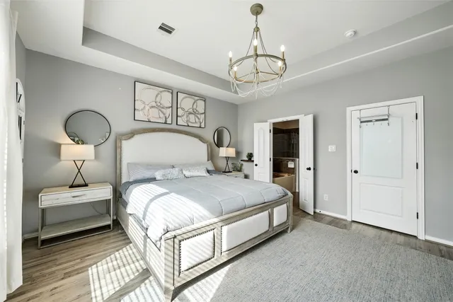 a bedroom with bed and a chandelier
