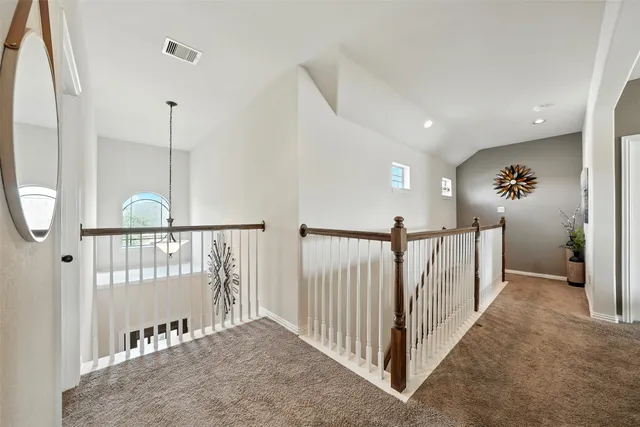 a bed sitting in a bedroom next to a window with a chandelier and dresser