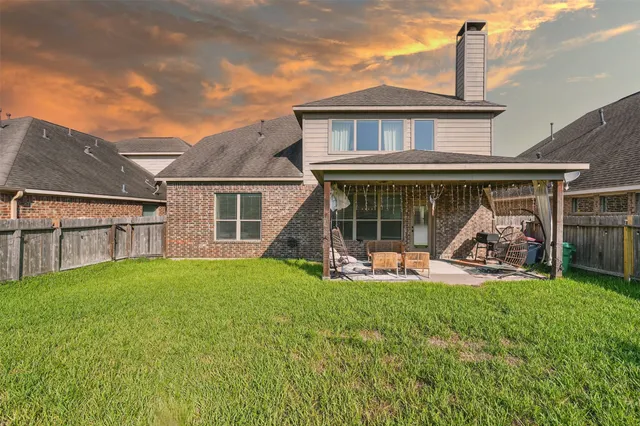 front view of a house with yard and a large tree