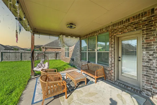 a patio with table and chairs and potted plants