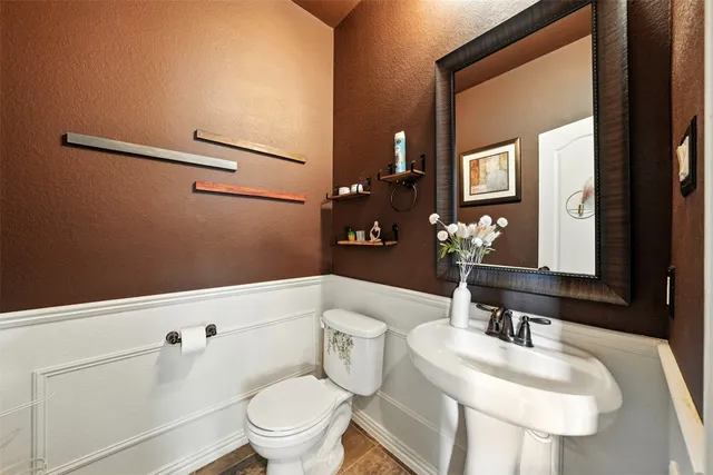 a bathroom with a sink a toilet and shower curtain