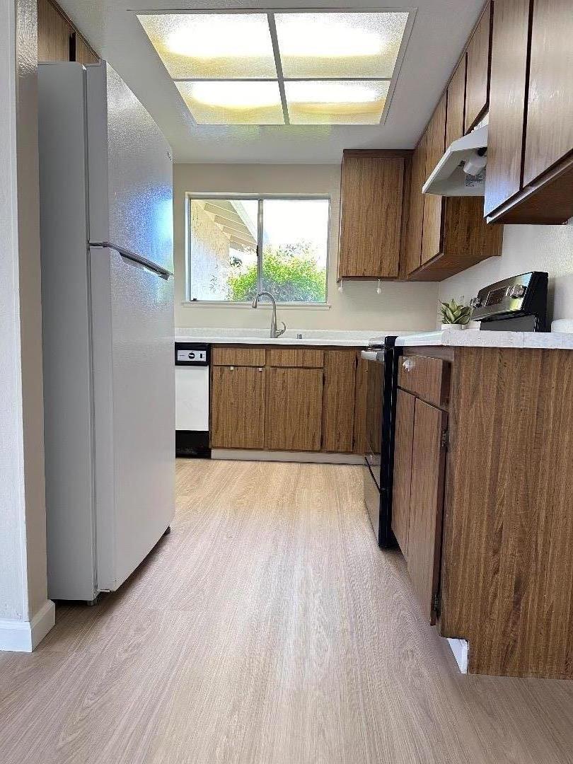 1710 Merrill Loop San Jose, CA 95124 - Photo 4 of 11 a view of a kitchen with wooden floor and a refrigerator