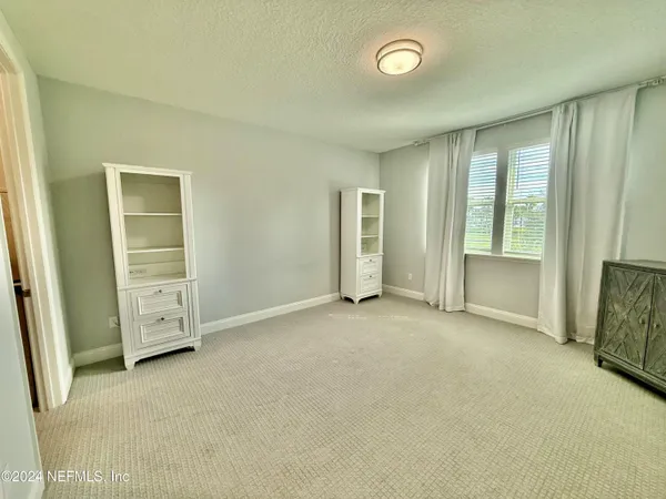 an empty room with windows and closet