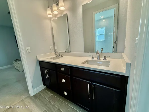 a bathroom with a double vanity sink and a mirror