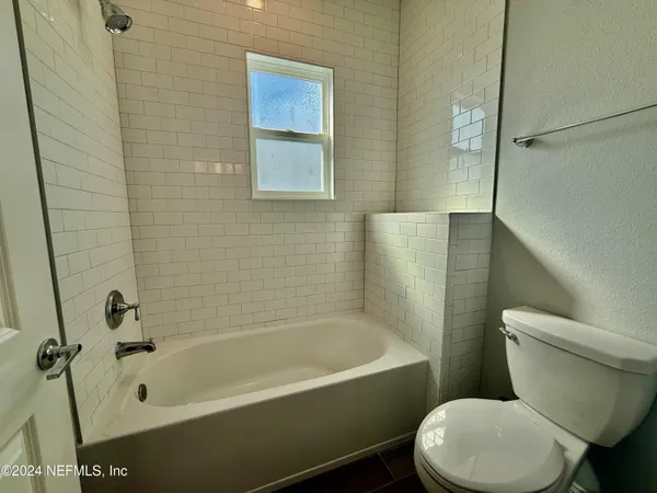 a white toilet sitting next to a bath tub and shower