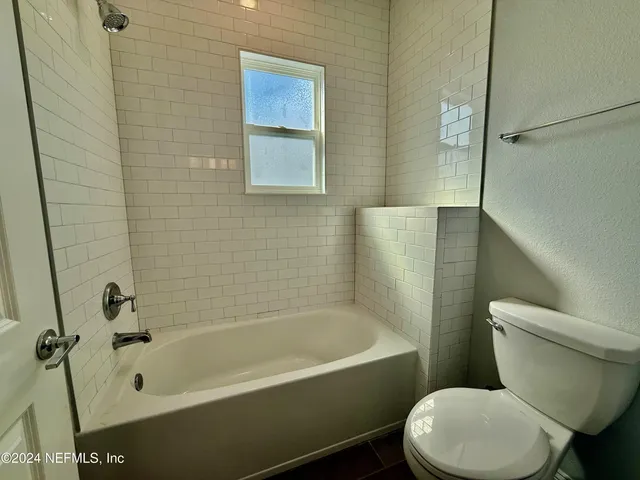 a white toilet sitting next to a bath tub and shower