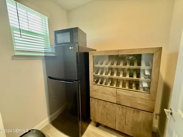 a kitchen with a refrigerator and wooden floor