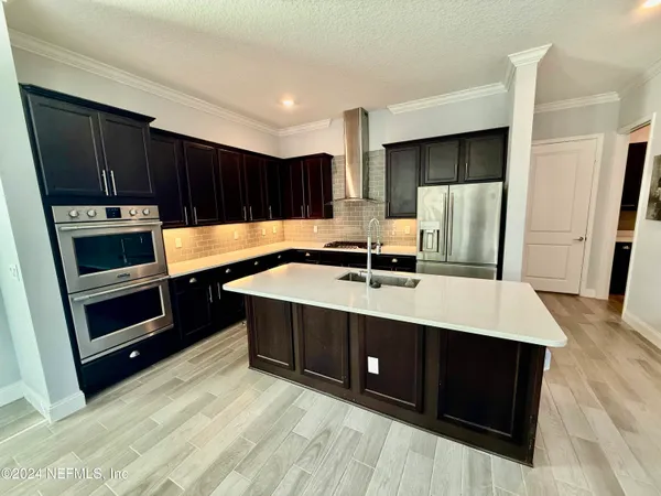 a kitchen with kitchen island a sink a stove and refrigerator