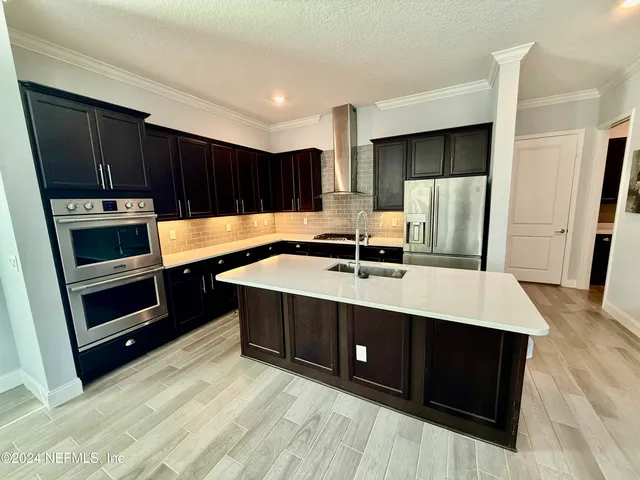 a kitchen with kitchen island a sink a stove and refrigerator
