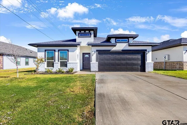 a front view of a house with a yard and garage