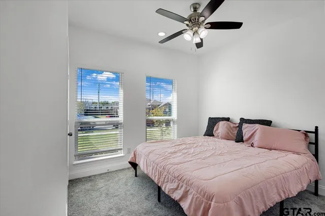 a bedroom with a bed ceiling fan and a window