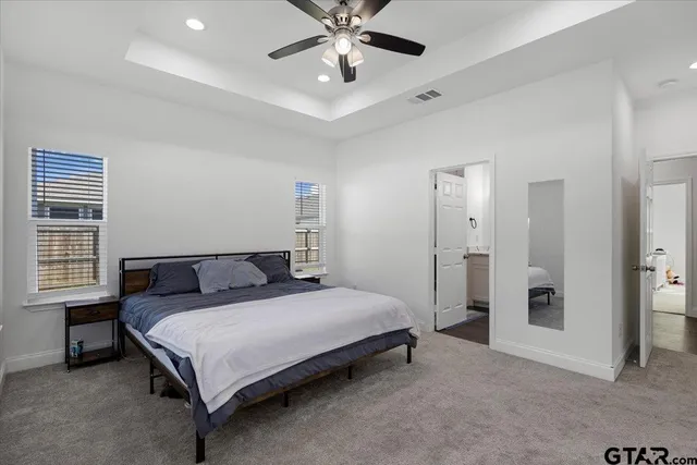 a spacious bedroom with a bed and a chandelier