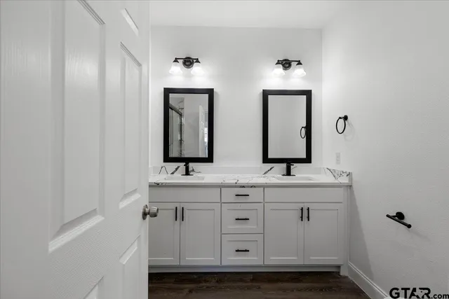 a bathroom with a double vanity sink and a mirror