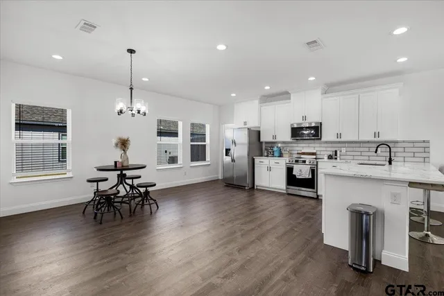 a kitchen with a table chairs refrigerator and cabinets