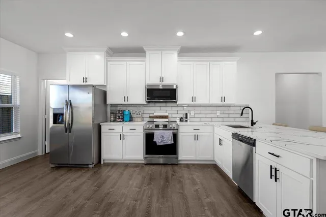 a kitchen with white cabinets and stainless steel appliances
